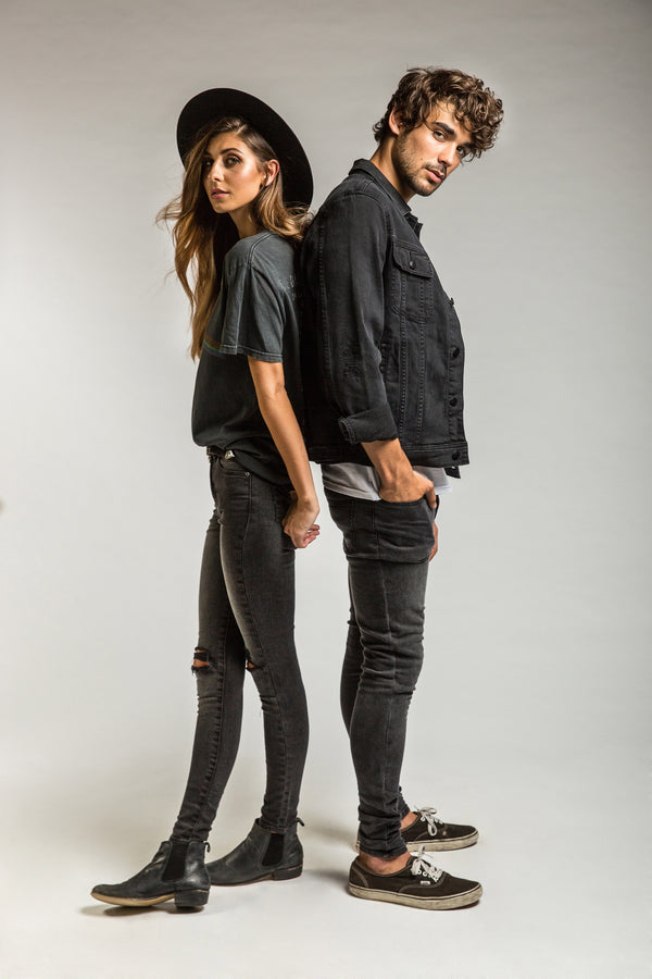 Man and woman in studio wearing denim standing back to back