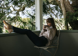 woman drinking tea wearing outland denim jeans