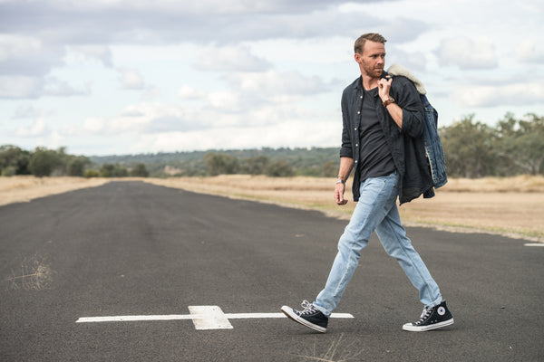 Man crossing road wearing outland denim jeans