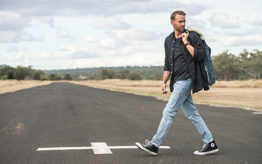 Man crossing road wearing outland denim jeans