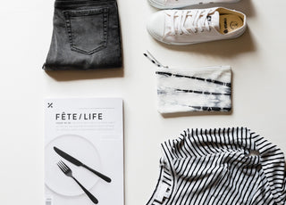 Flatlay of jeans, Fete magazine, and etiko shoes