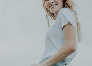 woman smiling wearing light blue jeans